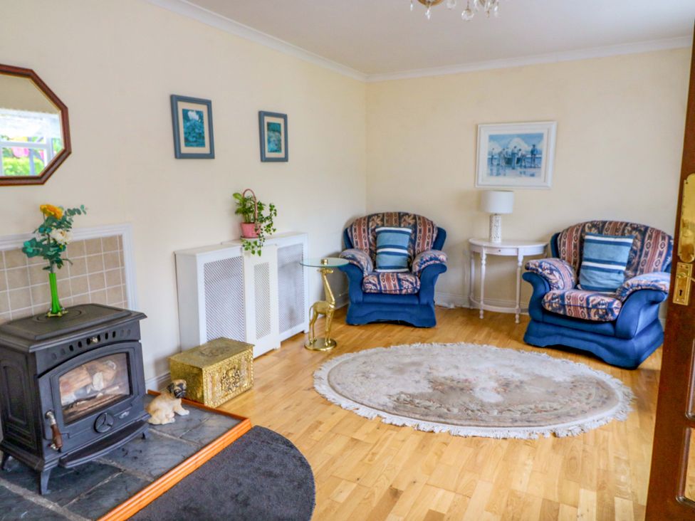 A living room with a fireplace and sofas at Waterfall House in Dunmanway, County Cork