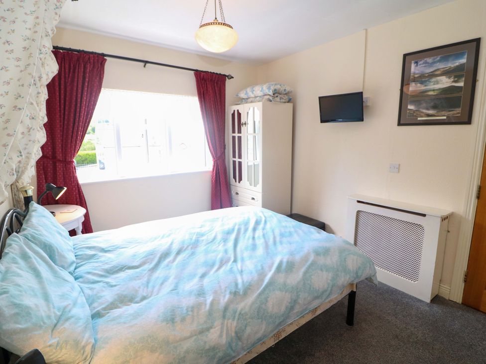 A bedroom with a bed and a wardrobe at Waterfall House in Dunmanway, County Cork