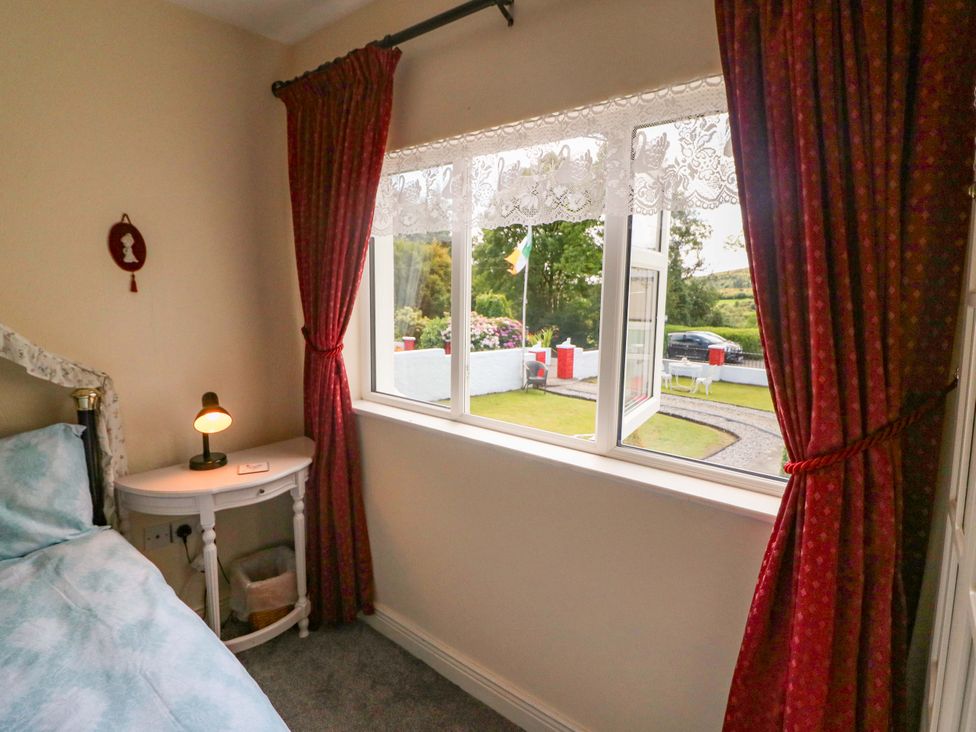 A bedroom with a bed and window at Waterfall House in Dunmanway, County Cork