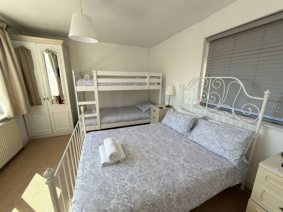 A bedroom with a double bed and bunk bed at Ryburn Lodge in Bridlington