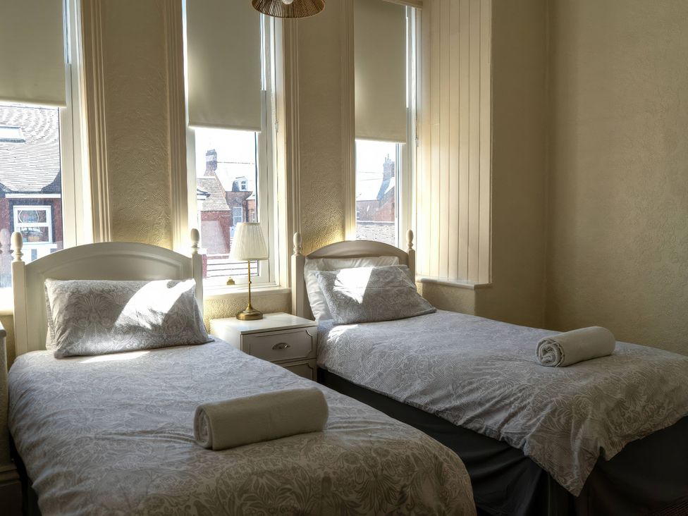 A bedroom with two single beds and a lamp at Ryburn Lodge in Bridlington