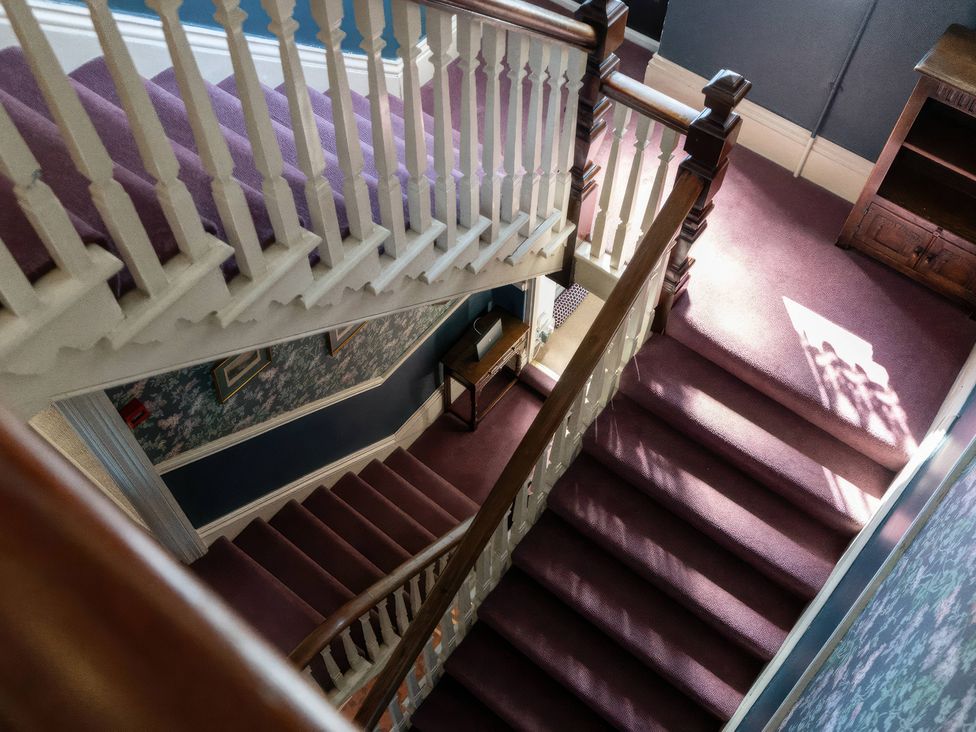 A staircase with a banister and carpet at Ryburn Lodge in Bridlington