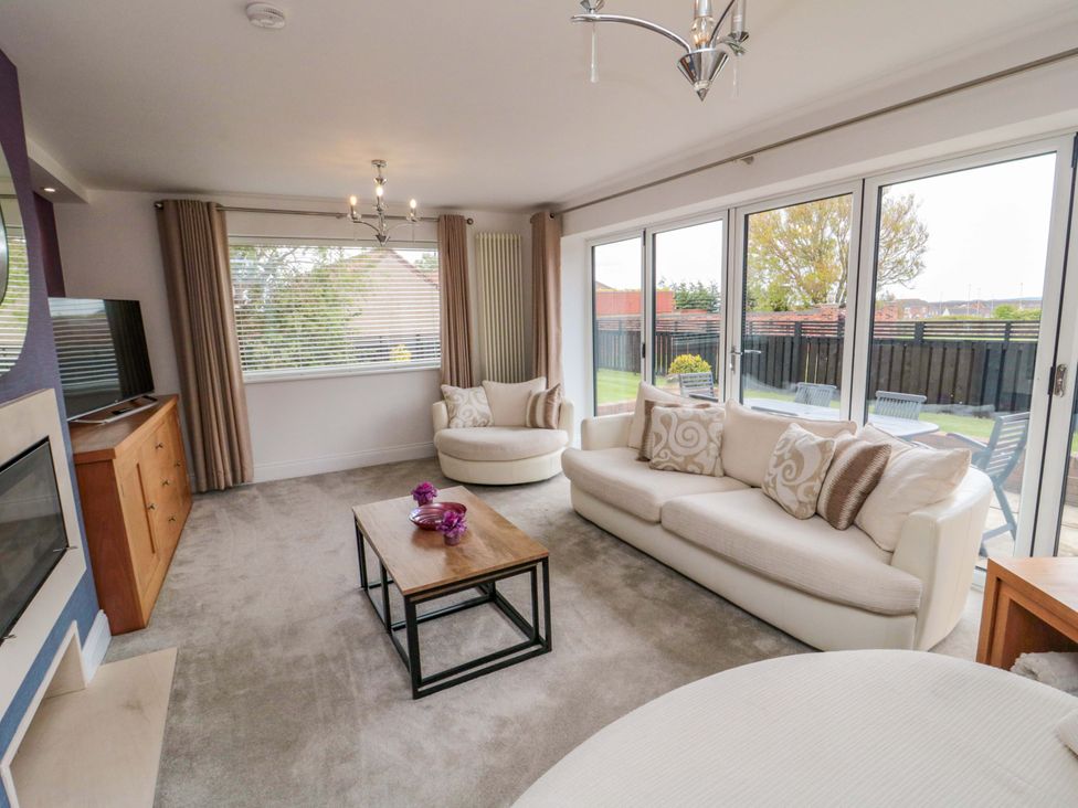 A living room with a sofa and television at Wyvill House in Cayton