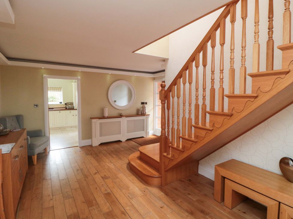A hallway with a staircase and a console table at Wyvill House in Cayton