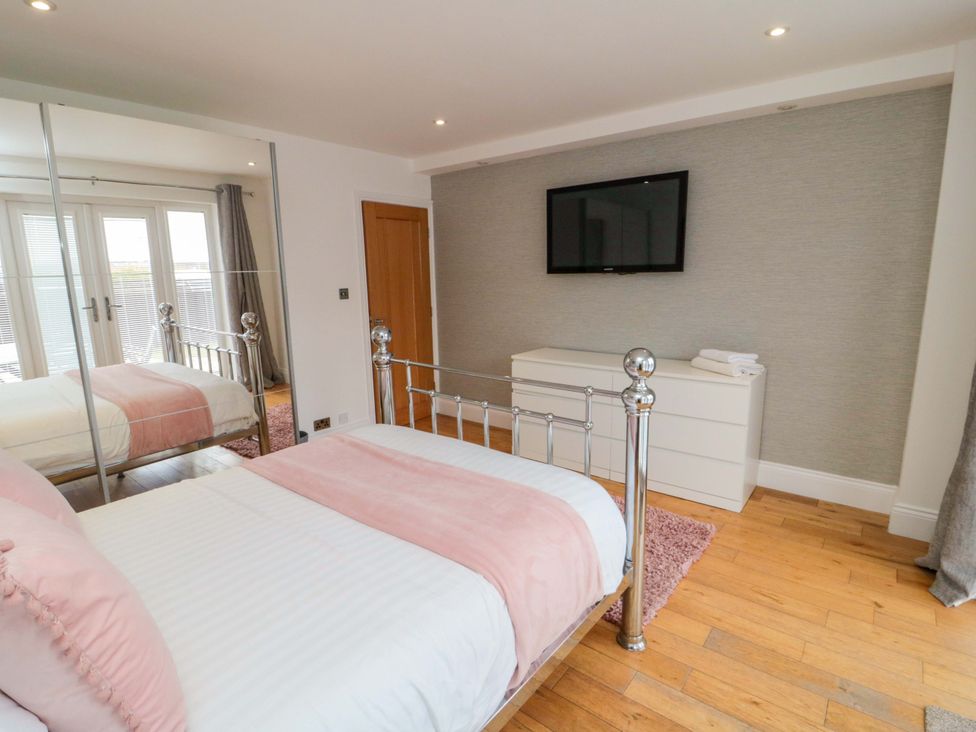 A bedroom with a bed and television at Wyvill House in Cayton