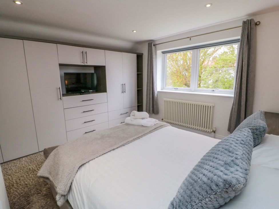 A bedroom with a bed and wardrobe at Wyvill House in Cayton