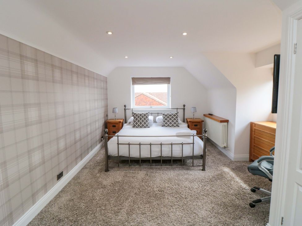 A bedroom with a bed and side tables at Wyvill House in Cayton