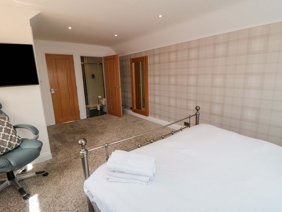 A bedroom with a bed and armchair at Wyvill House in Cayton