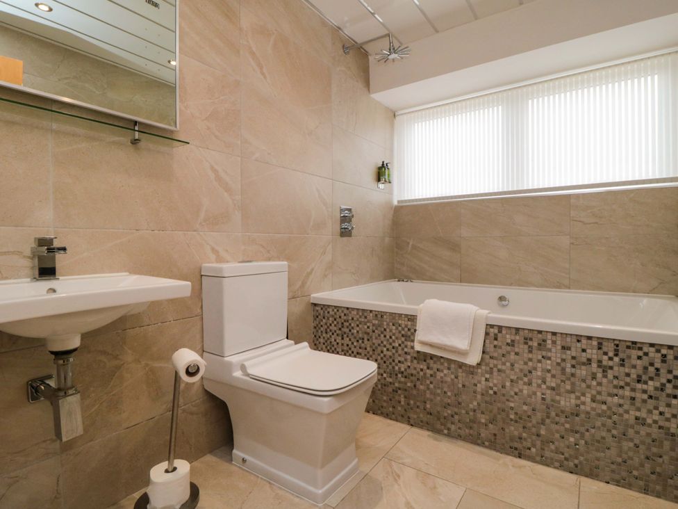 A bathroom with a bathtub, toilet, and sink at Wyvill House in Cayton