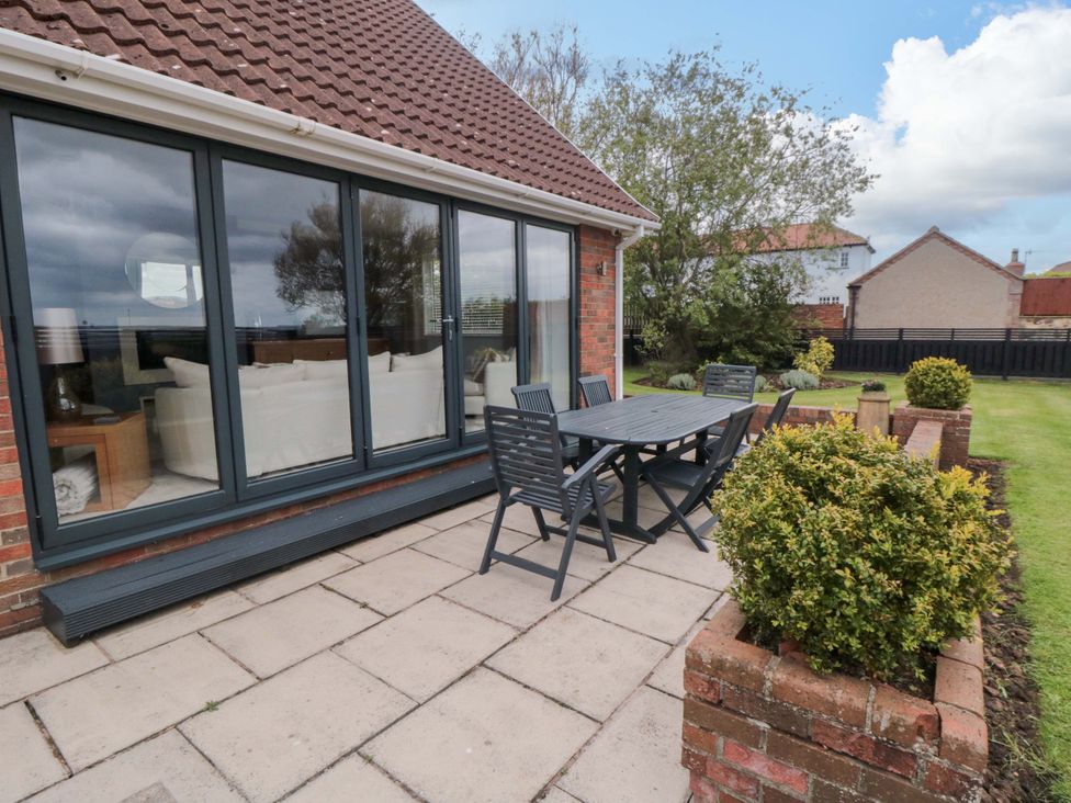 A garden with a table and chairs at Wyvill House in Cayton