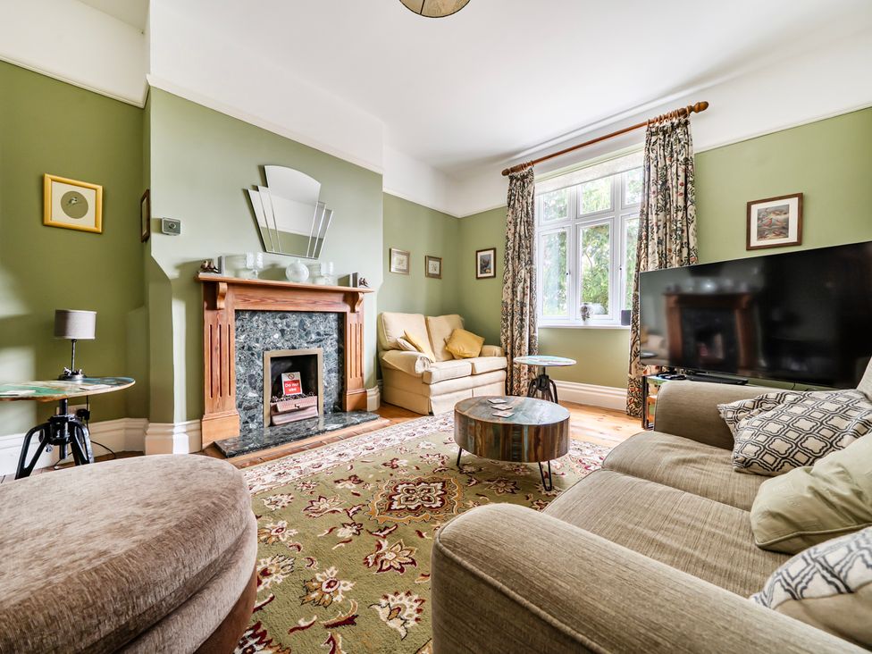 A living room with a fireplace and sofa at High House in Southrepps