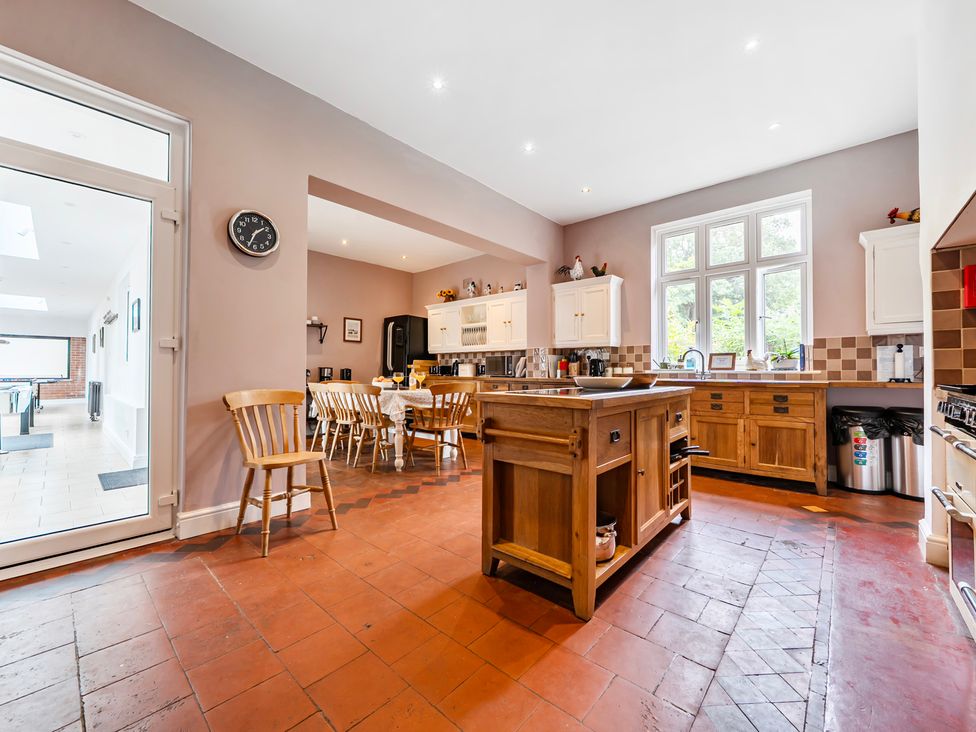 A kitchen with cabinets and dining area at High House in Southrepps