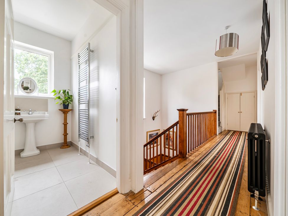 A hallway with a staircase and a sink at High House Southrepps