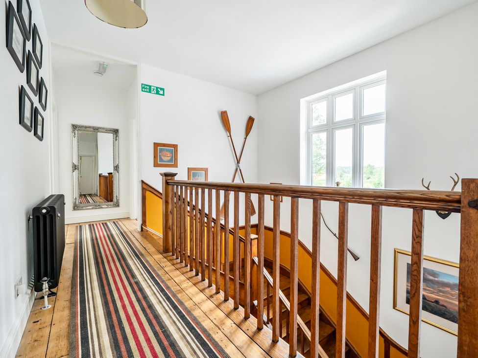 A hallway with stairs and a mirror at High House in Southrepps