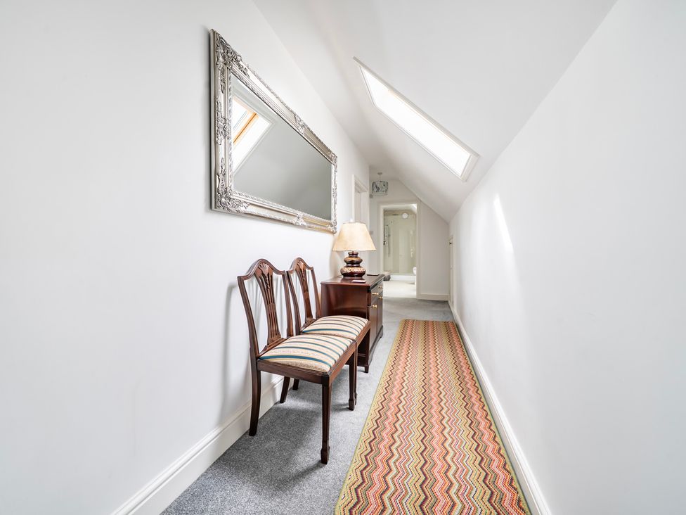 A hallway with a bench and a mirror at High House in Southrepps
