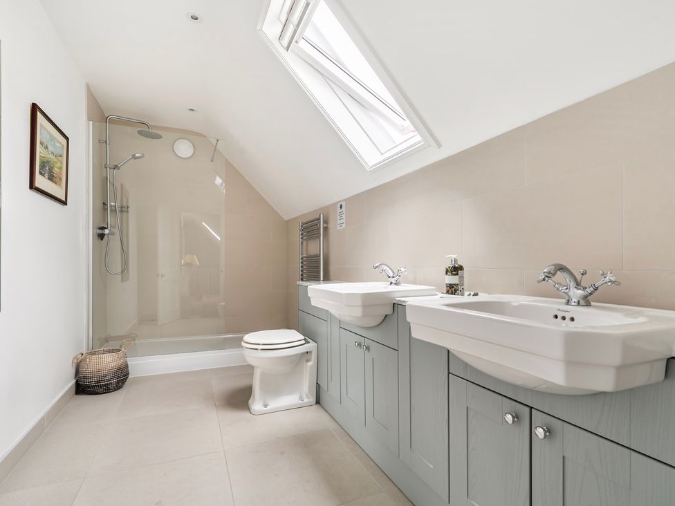 A bathroom with a shower and double sink at High House in Southrepps
