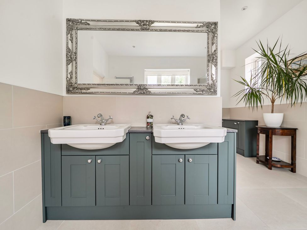 A bathroom with double sinks and a large mirror at High House Southrepps