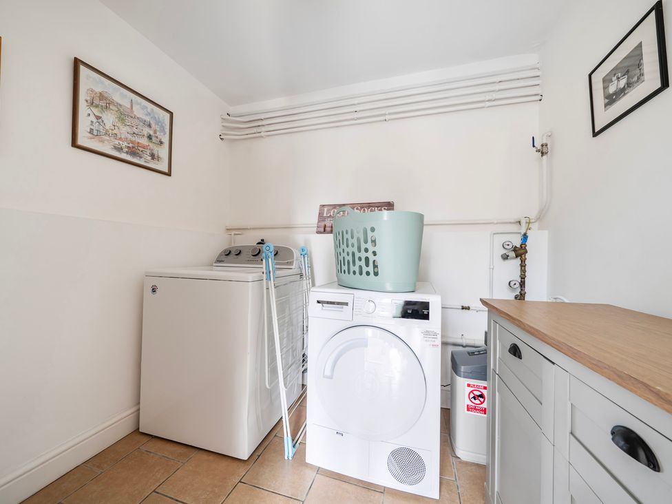 A laundry room featuring a washing machine and tumble dryer at High House in Southrepps