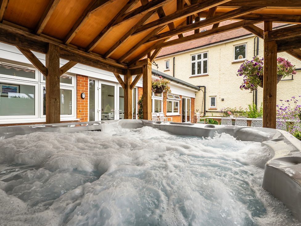 A hot tub under a wooden structure at High House in Southrepps