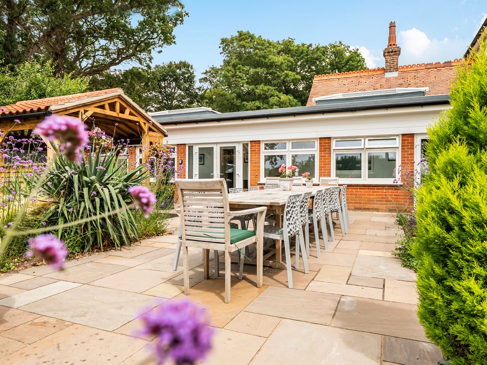 An outdoor seating area with a dining table and chairs at High House in Southrepps