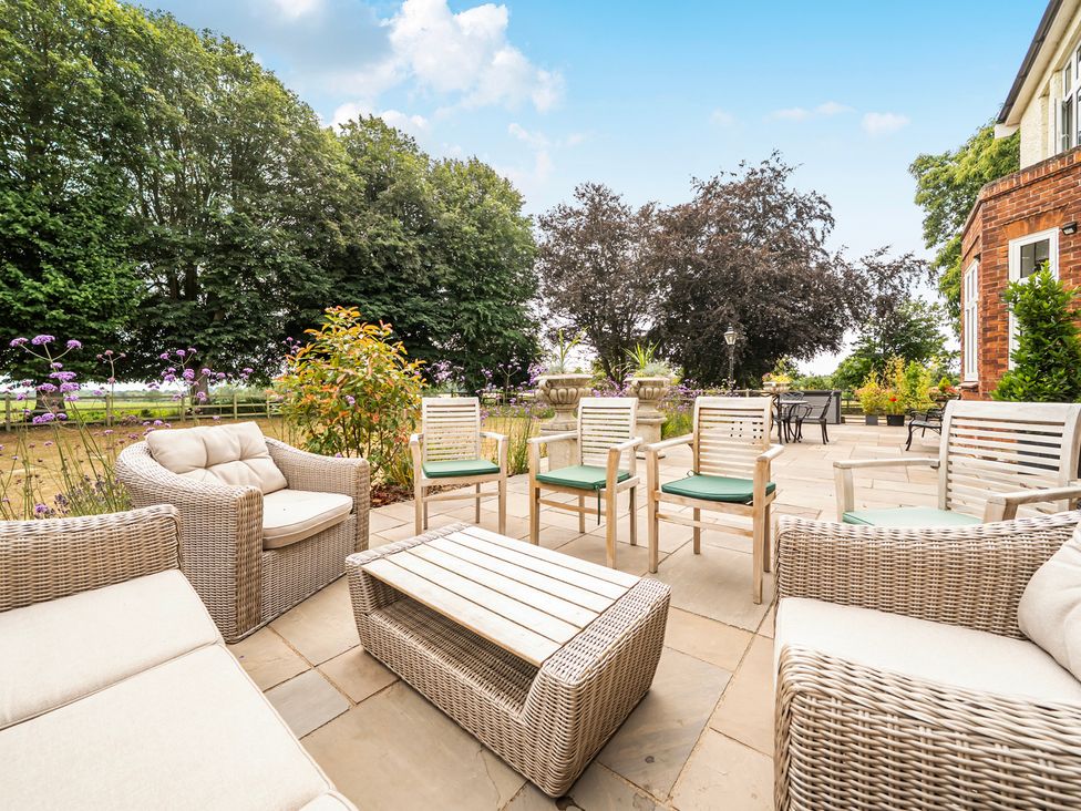 A patio with seating and plants at High House in Southrepps