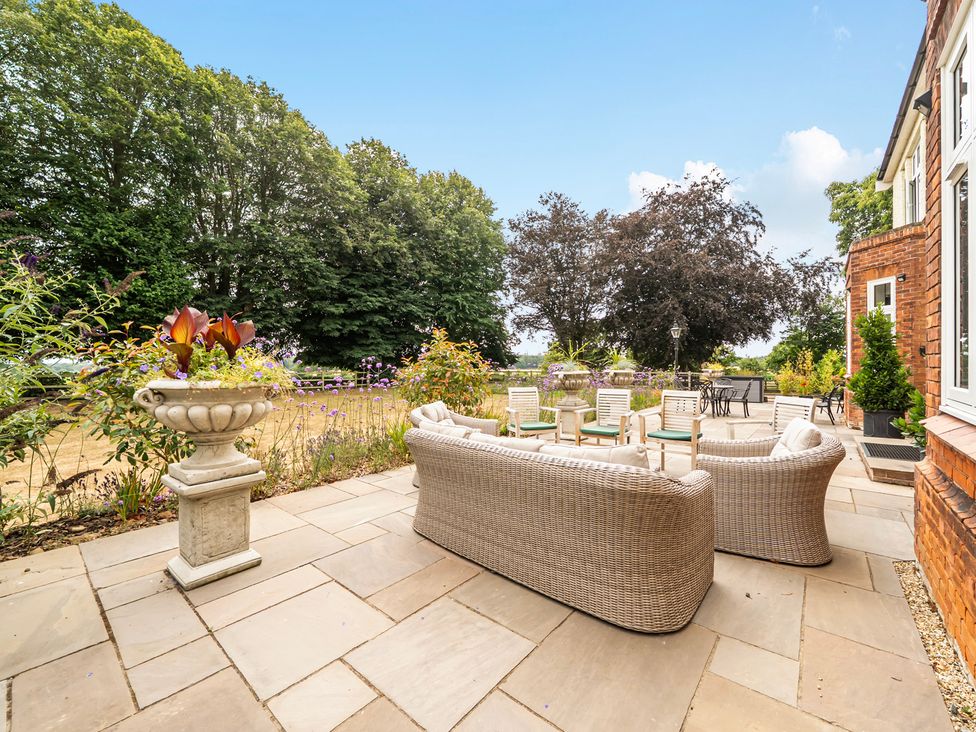 An outdoor seating area with a table and planter at High House in Southrepps