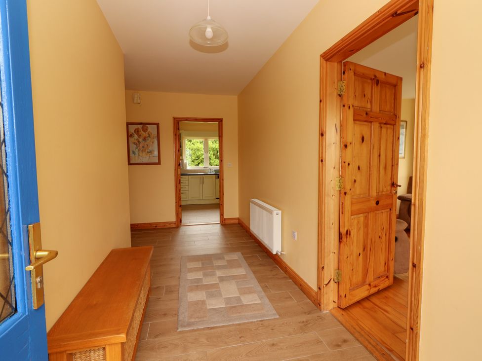 A hallway with a bench and a painting at 29 Church Field in Doonbeg, County Clare