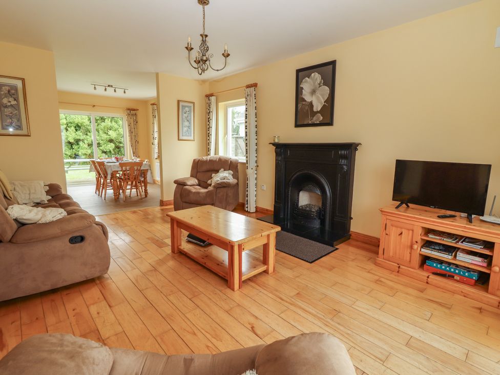A living room with a fireplace and a dining area at 29 Church Field, Doonbeg, County Clare