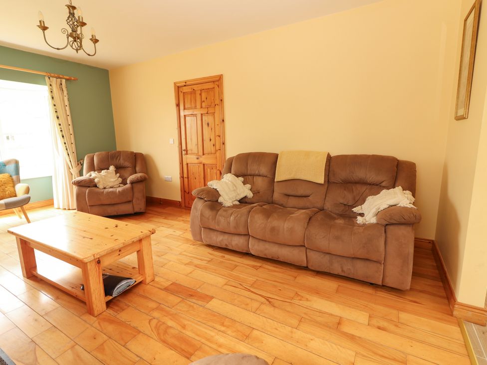 A living room with a sofa and armchairs at 29 Church Field, Doonbeg, County Clare