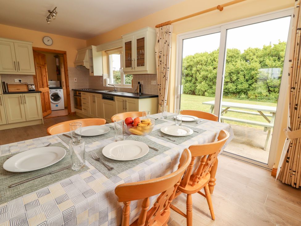 A kitchen with a dining table set for a meal at 29 Church Field in Doonbeg, County Clare