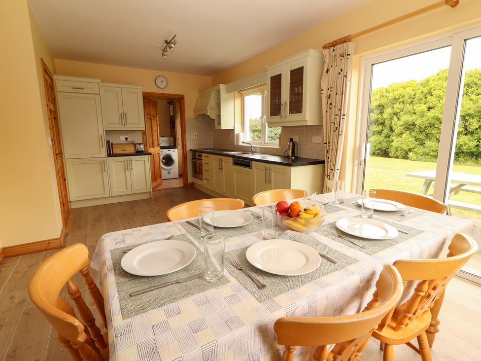 A kitchen with dining table and chairs at 29 Church Field in Doonbeg, County Clare