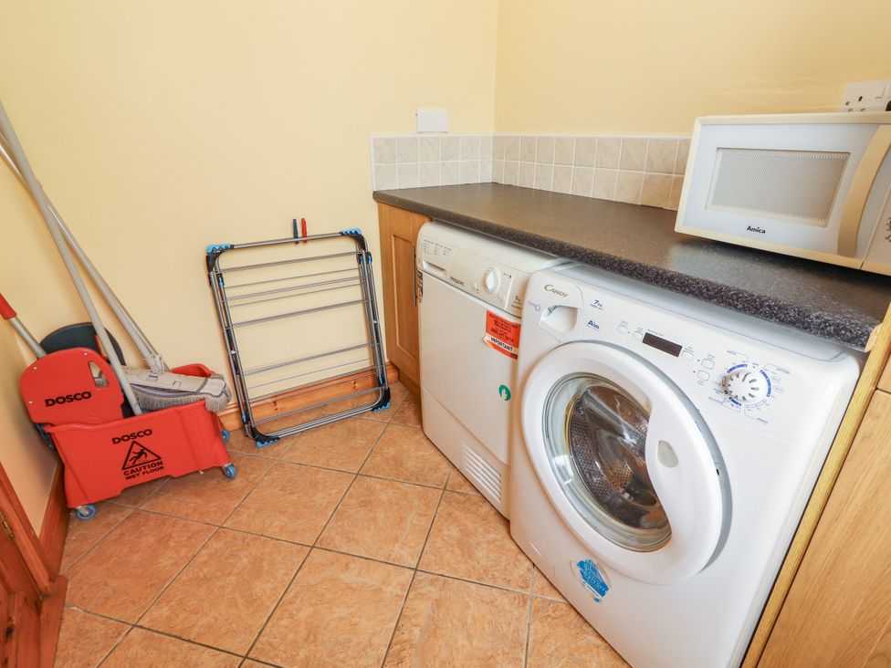 A utility room with a washing machine and dryer at 29 Church Field, Doonbeg, County Clare