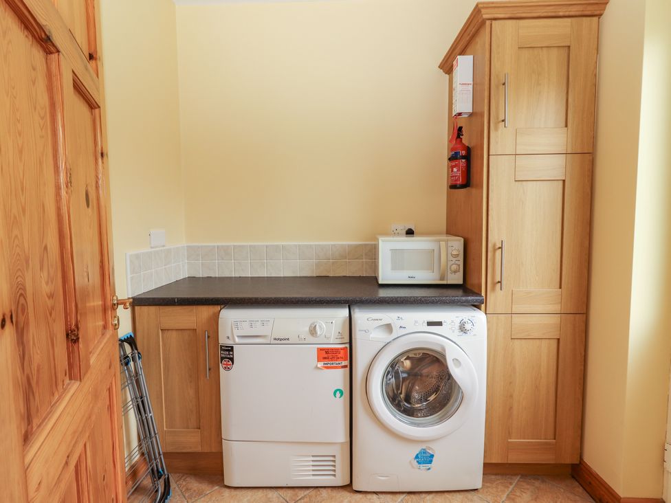 A utility room with a washing machine and dryer at 29 Church Field in Doonbeg, County Clare