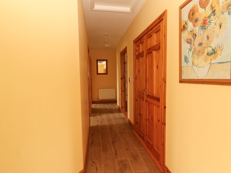 A hallway with doors and a mirror at 29 Church Field in Doonbeg, County Clare