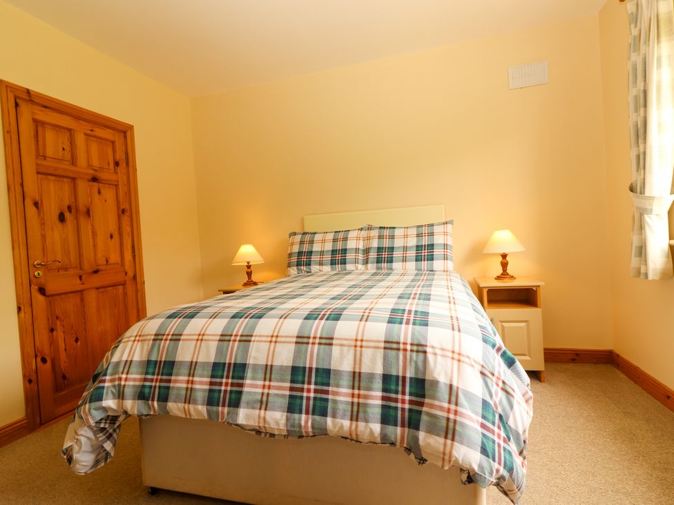 A bedroom with a bed and bedside lamps at 29 Church Field in Doonbeg, County Clare