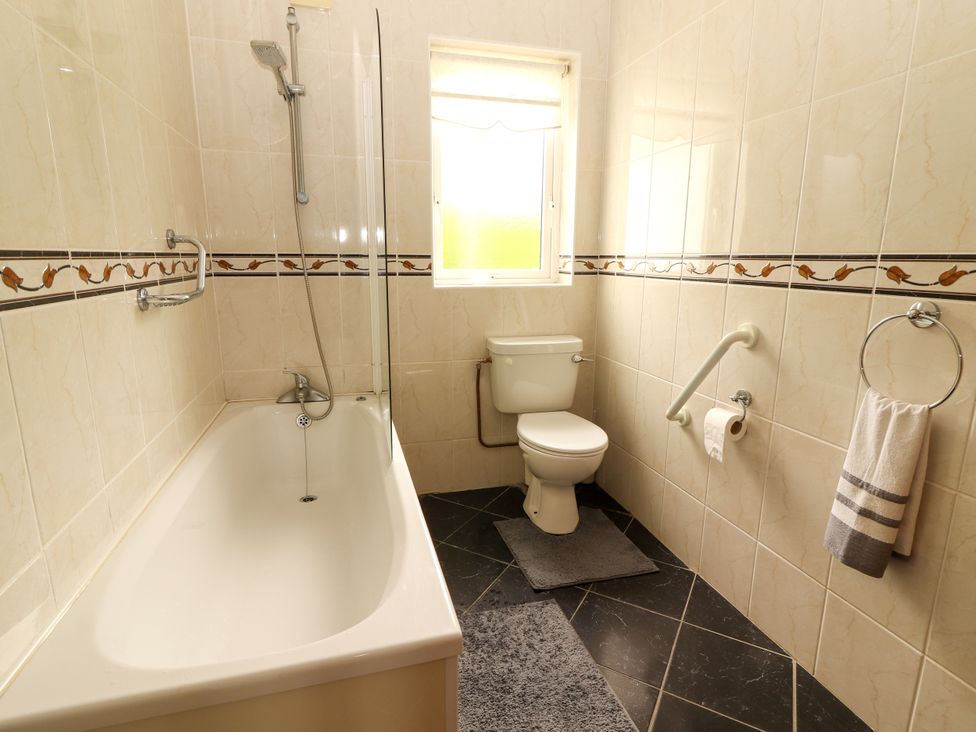 A bathroom with a bathtub and toilet at 29 Church Field, Doonbeg, County Clare