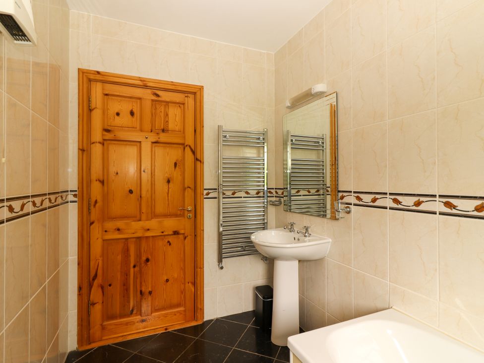 A bathroom with a towel warmer and sink at 29 Church Field in Doonbeg, County Clare