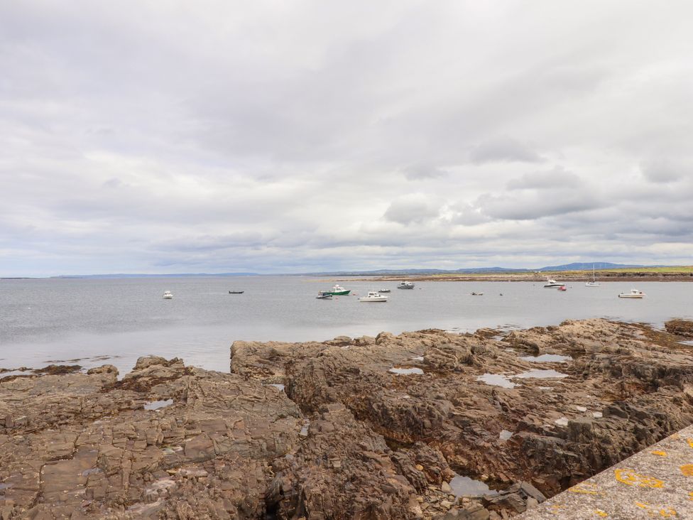 A view of the sea with rocks and boats at 29 Church Field in Doonbeg, County Clare
