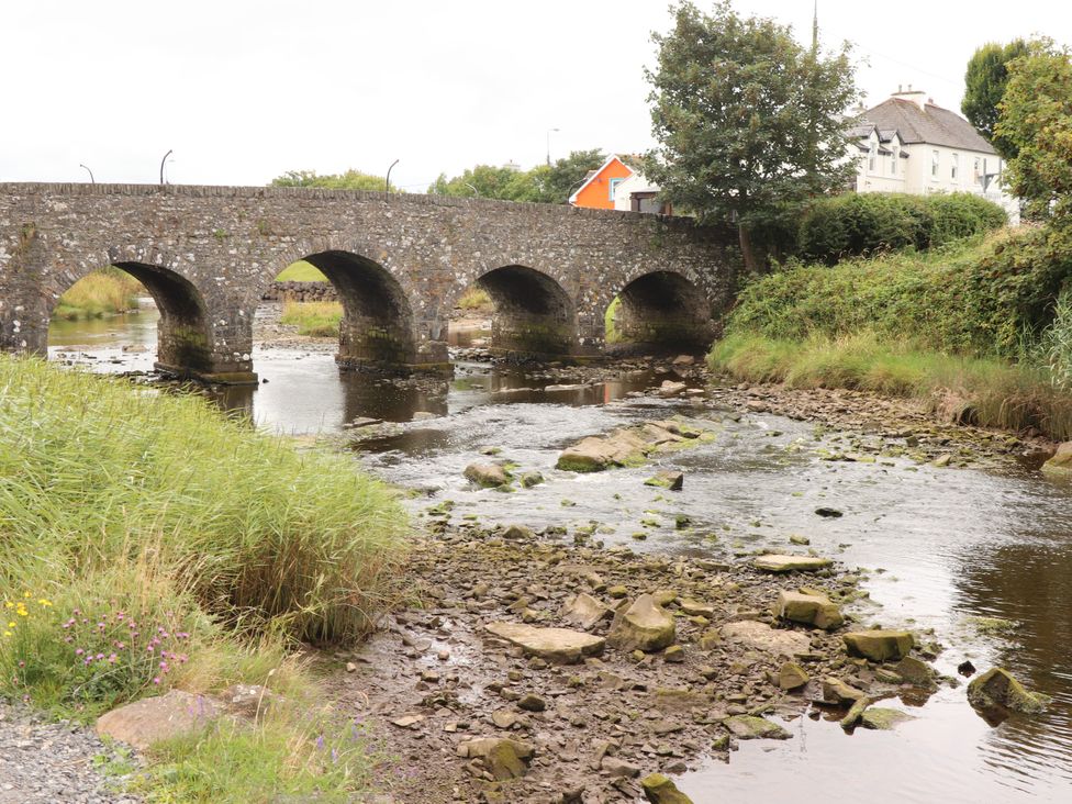 A bridge over a stream with grass and stones at 29 Church Field, Doonbeg, County Clare