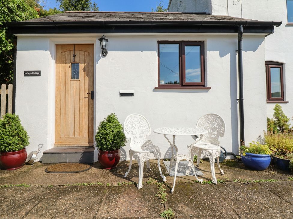 A front entrance with a door and outdoor seating at Alwyn Cottage in Froncysyllte