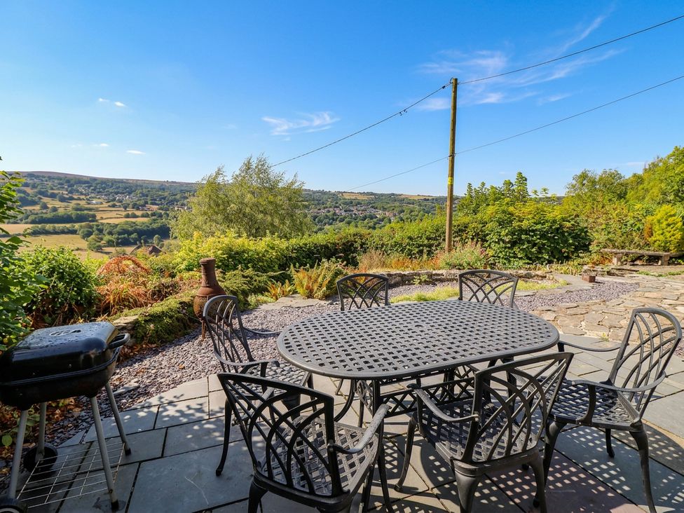 An outdoor dining area with a table and chairs and a view at Alwyn Cottage in Froncysyllte