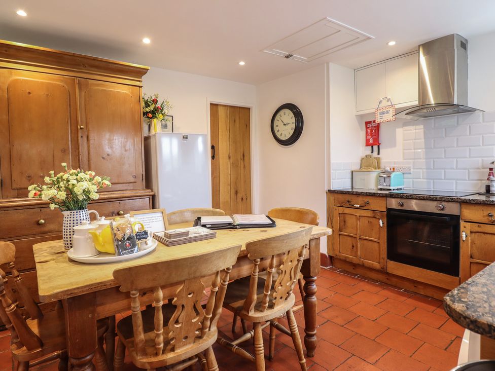 A kitchen with a table and chairs at Alwyn Cottage in Froncysyllte