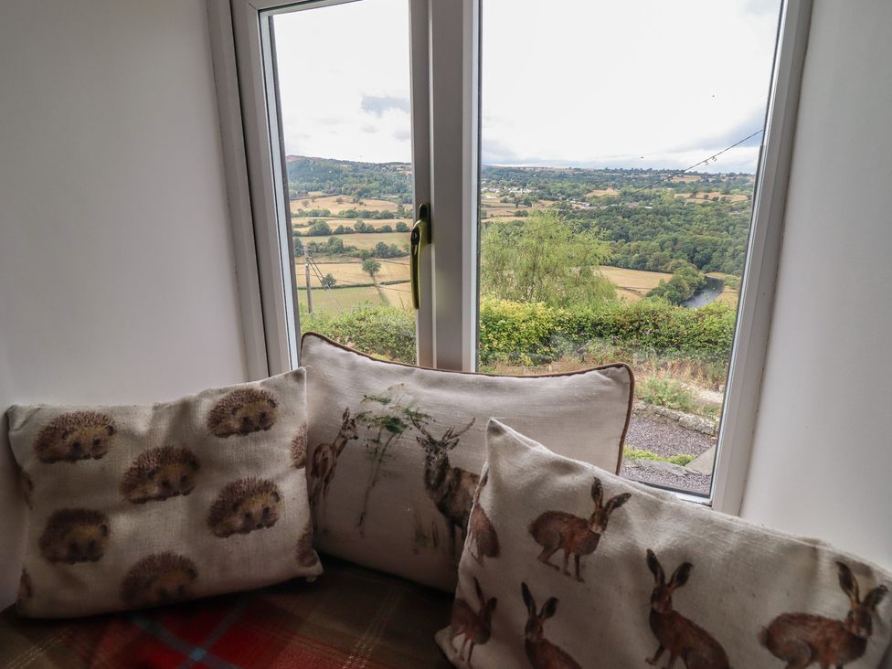 A living room with cushions and a view of the landscape at Alwyn Cottage in Froncysyllte