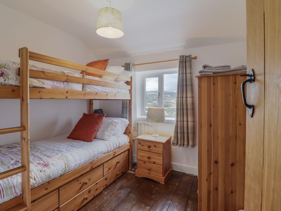 A bedroom with a bunk bed and a bedside table at Alwyn Cottage in Froncysyllte