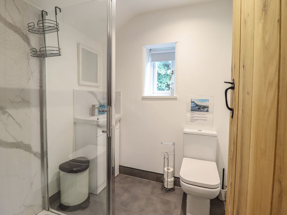 A bathroom with a shower, toilet, and sink at Alwyn Cottage in Froncysyllte