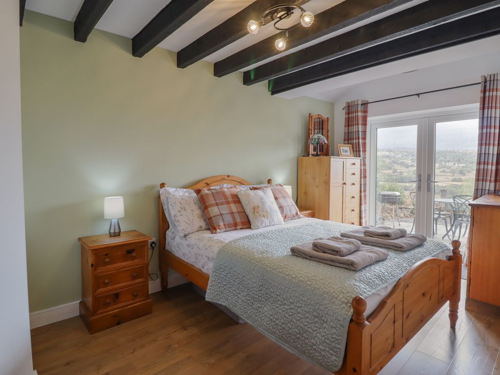 A bedroom with a bed and nightstand at Alwyn Cottage in Froncysyllte