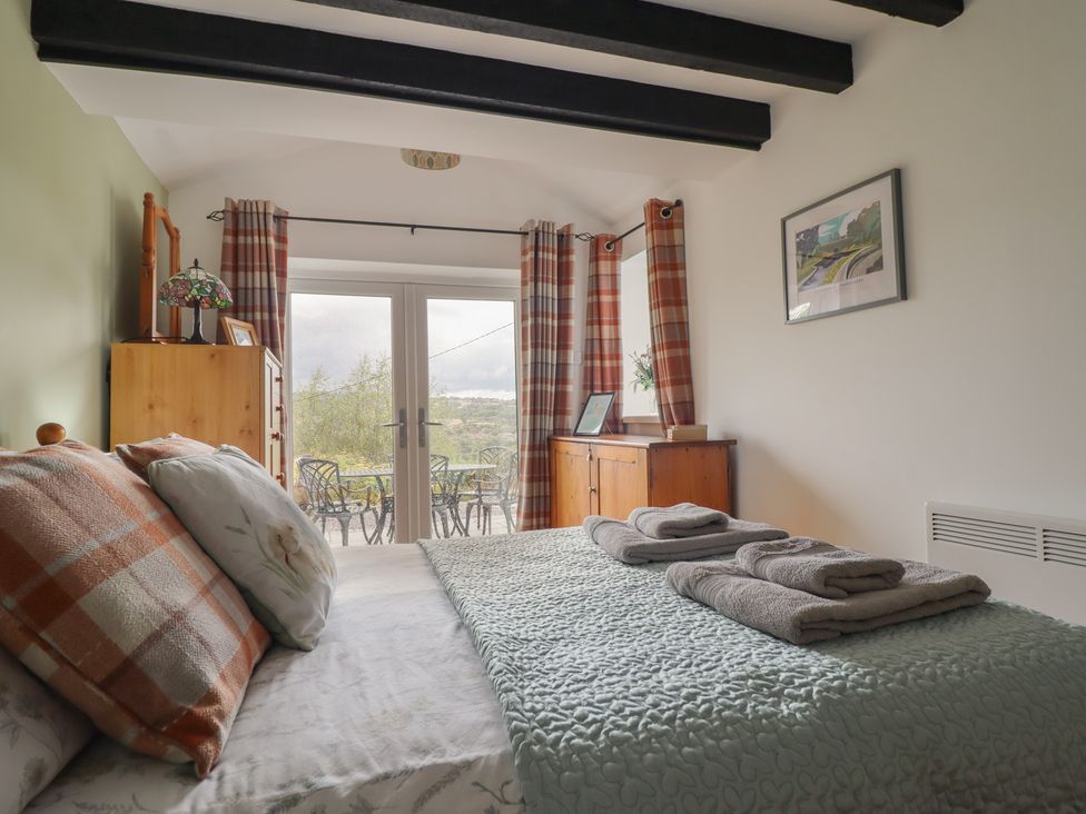 A bedroom with a bed and dresser at Alwyn Cottage Froncysyllte