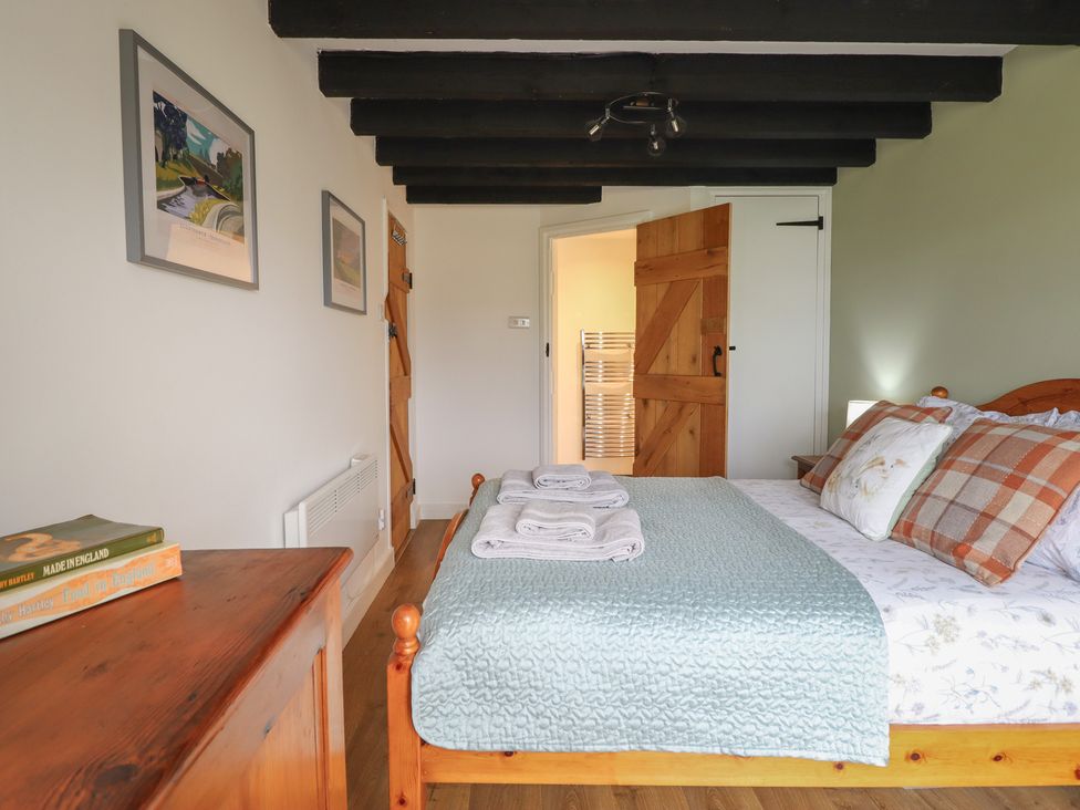 A bedroom with a bed and towels at Alwyn Cottage in Froncysyllte