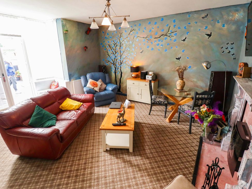 A living room with a sofa and chairs at Peartree Cottage