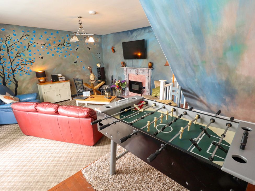 A living room with a foosball table and sofa at Peartree Cottage